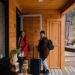 Two guests with luggage arriving at a wooden holiday cabin