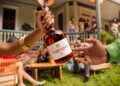 A Courvoisier VS bottle being passed between two hands at a house party, from the Pass The Courvoisier campaign
